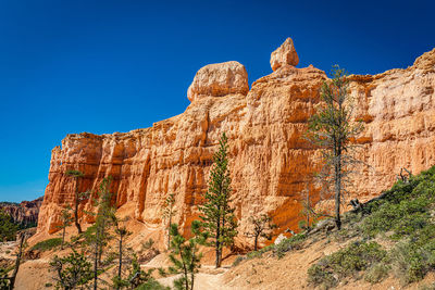 Rock formations on mountain against blue sky