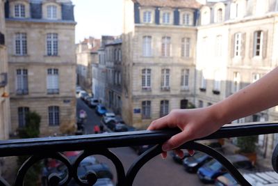 Close-up of hand on railing in city