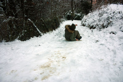 People sitting on snow covered land