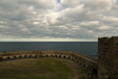 Yoros castle by sea against cloudy sky