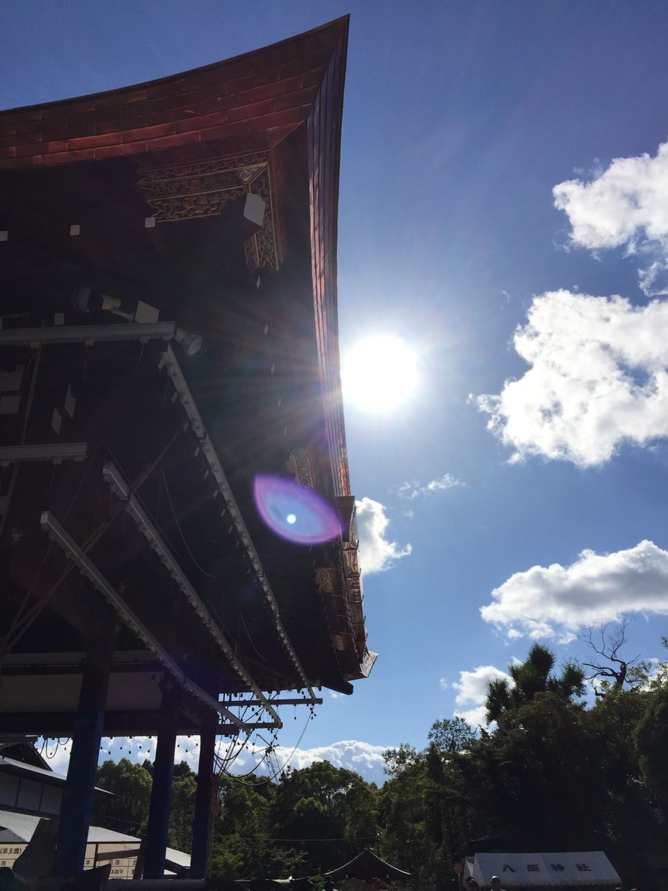 low angle view, sky, built structure, architecture, sunlight, building exterior, sun, sunbeam, tree, lens flare, blue, cloud - sky, no people, outdoors, day, cloud, sunny, house, nature, metal