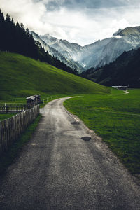 Road leading towards mountains against sky