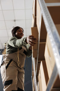 Low angle view of woman standing by railing