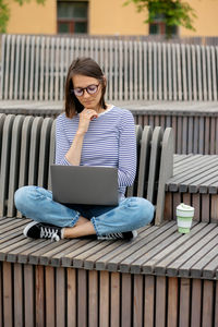 A female blogger with a laptop and a smartphone records content for her subscribers. work online