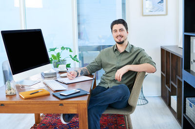 Portrait of young man using laptop at home