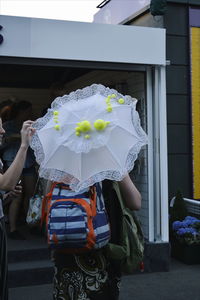 Rear view of woman with tennis ball umbrella 