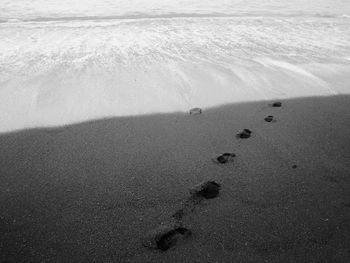 High angle view of footprints on sand at beach