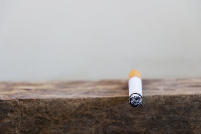 Close-up of cigarette on retaining wall