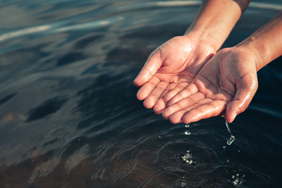 High angle view of hands over water