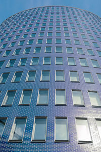 Low angle view of modern building against blue sky