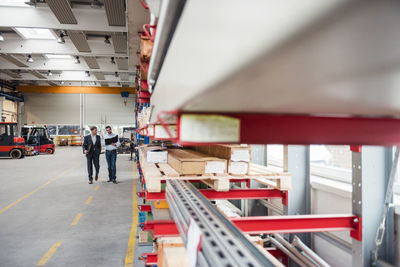 Two men walking and talking in factory shop floor