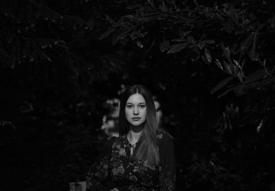 Portrait of woman standing by tree