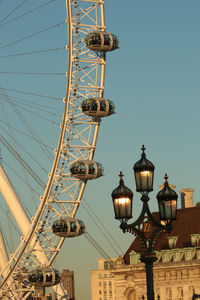 Low angle view of ferris wheel against clear blue sky