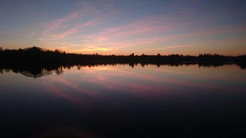 Scenic view of calm lake at sunset