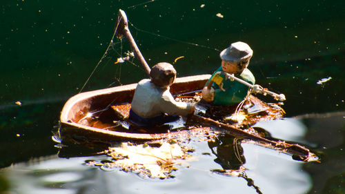 Men sitting on boat in lake