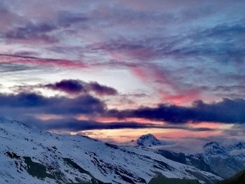 Scenic view of snowcapped mountains against dramatic sky