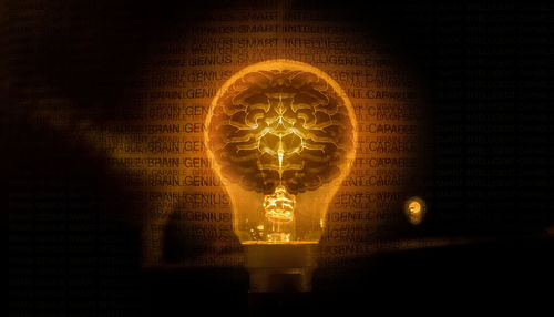 Close-up of illuminated light bulb against black background