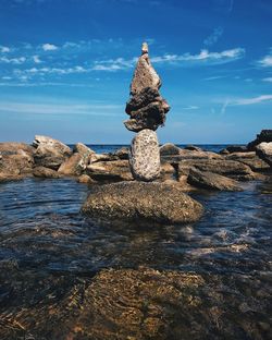 Stack of rocks on beach against sky