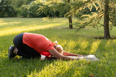 Low section of woman exercising on field
