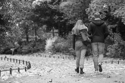 Full length rear view of man and woman walking at st stephen green