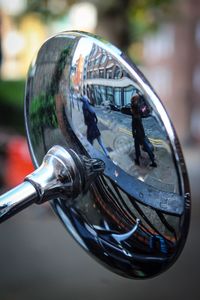 Close-up of person with reflection on metal