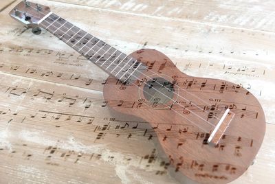 Double exposure of guitar with sheet music