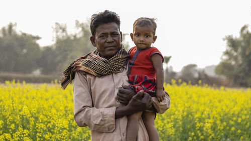 Portrait of father and son on field