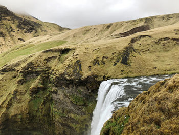 Scenic view of waterfall against sky