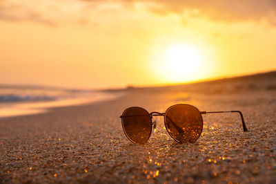 Mirrored sunglasses lie on a sandy beach. close-up of sunglasses, beautiful trendy sunglasses