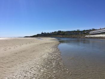 Scenic view of beach against clear blue sky