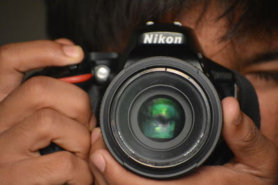 Cropped image of man photographing with camera