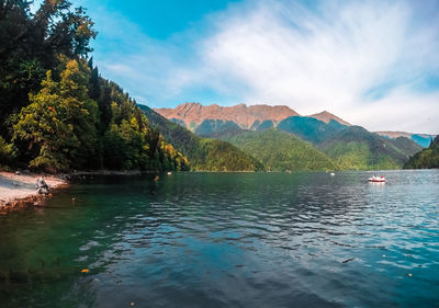 Scenic view of lake by mountains against sky