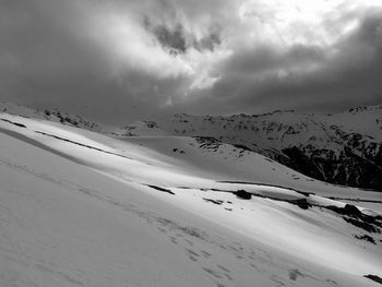 Scenic view of snowcapped mountains against cloudy sky