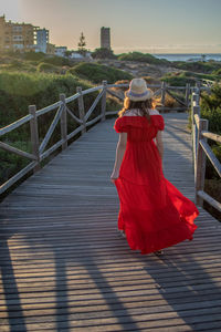 Rear view of woman walking on footbridge