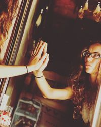 Young woman looking in mirror at home