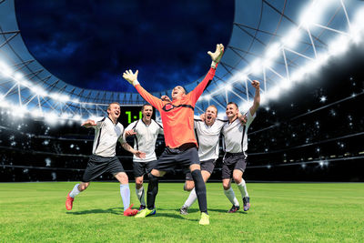 Happy players running on soccer field