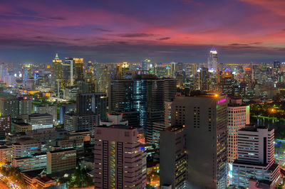 Illuminated buildings in city against sky at night