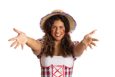 Portrait of smiling young woman standing against white background