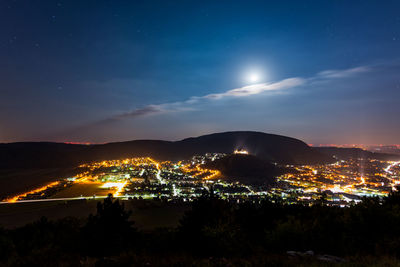 Illuminated cityscape against sky at night