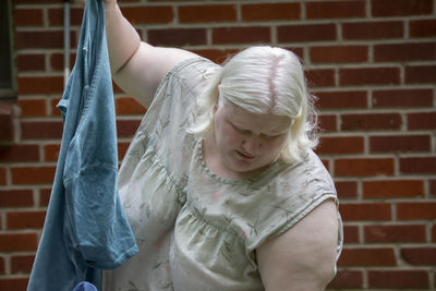 Albino woman folding clothes outdoors