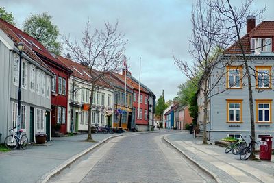 Street amidst houses and buildings against sky