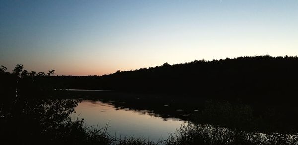 Scenic view of lake against clear sky during sunset