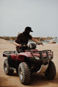 Rear view of man riding motorcycle on land