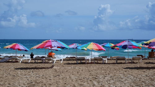 People at beach against sky