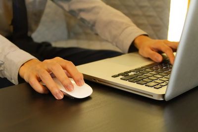 Midsection of man using laptop