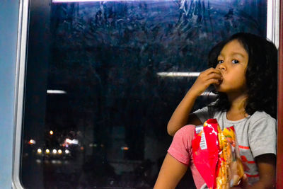 Portrait of woman looking through glass window