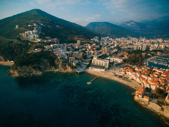 High angle view of townscape by sea against sky