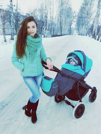 Portrait of smiling young woman playing in snow