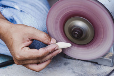 Midsection of man polishing wooden equipment