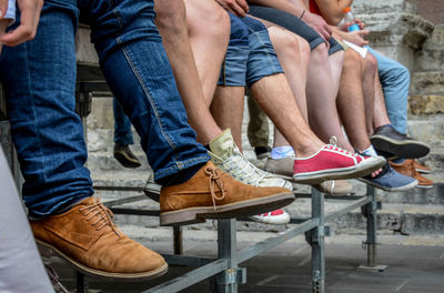 Low section of men sitting on bench